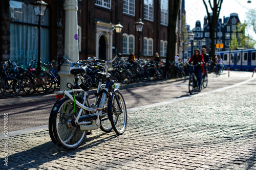 Bicycles parked on the city street on sunny day in Amsterdam, Th