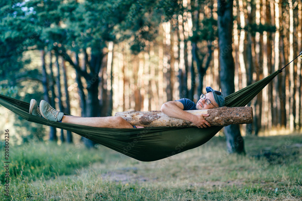 Odd weird strange unusual male person. Outlandish funny crazy foolish man sleeping in hammock with huge Odd weird strange unusual male person. Outlandish funny crazy foolish man sleeping in hammock with huge