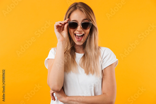 Portrait of an excited young blonde girl in sunglasses photo