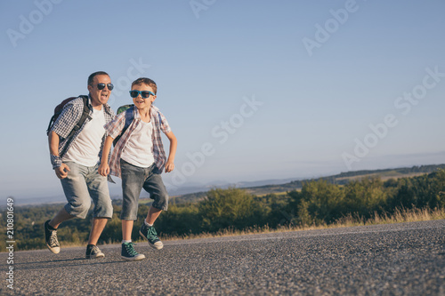 Father and son running on the road at the day time.