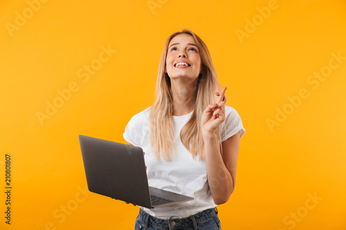 Portrait of a smiling young blonde girl holding laptop photo