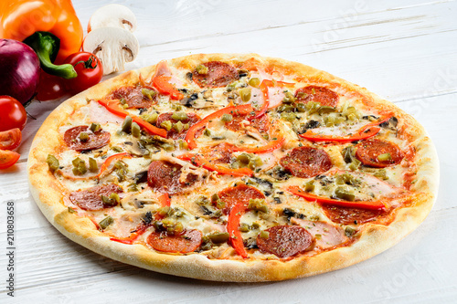 Appetizing hot Italian pizza with cheese, salami and pepper on r