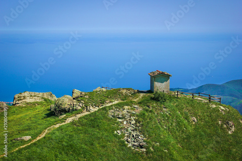 Alpine landscape with small soldiers monument facing the Mediteranean Sea in Beigua National Geopark, Liguria, Italy