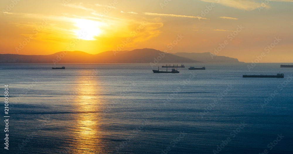 Bulk-carrier Ship At Sunset In The Sea On Sunset. Gelendzhik, Russia Bulk-carrier Ship At Sunset In The Sea On Sunset. Gelendzhik, Russia