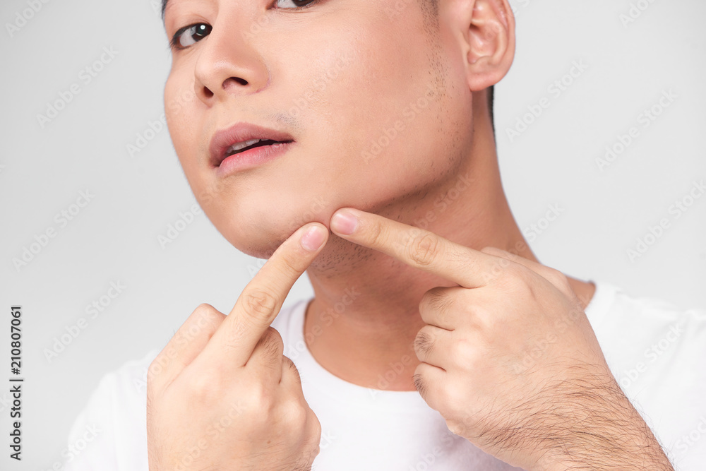 Close up photo of young man looking for acnes on his face Close up photo of young man looking for acnes on his face