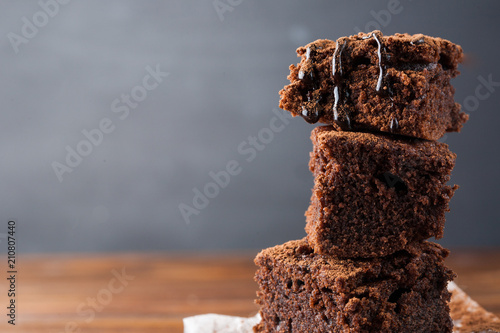 Homemade brownies on dark moody background. Chocolate cake closeup. Copy space.