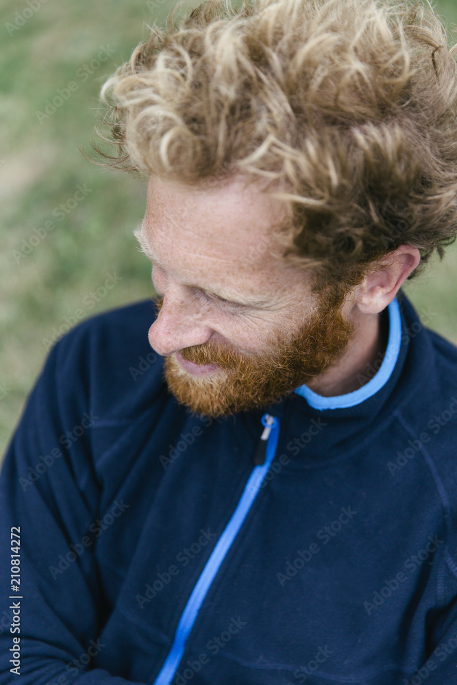A red bearded man with blonde curls in a dark blue cardigan. A red bearded man with blonde curls in a dark blue cardigan.