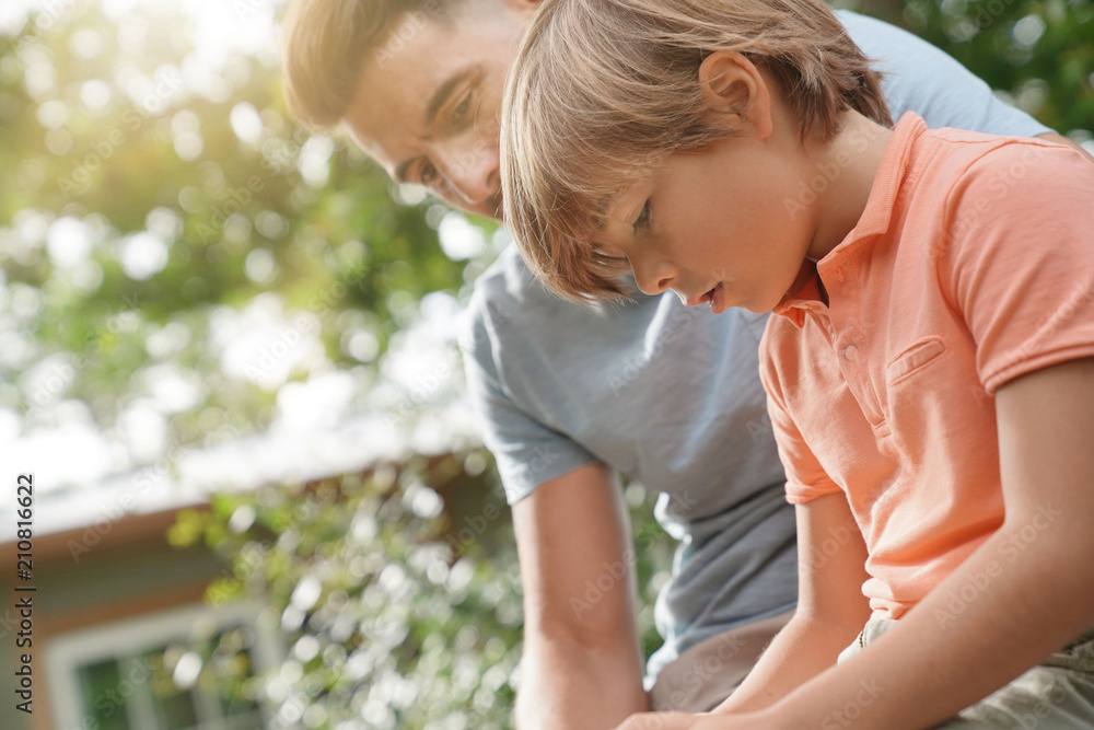 Daddy watching kid playing with video game console