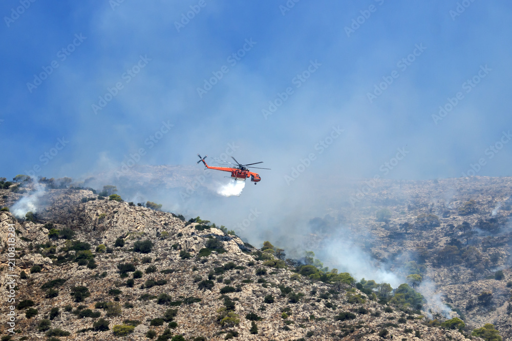 Fire helicopter extinguishes the fire on the hillside . Greece. The end of the summer.. Fire helicopter extinguishes the fire on the hillside . Greece. The end of the summer..