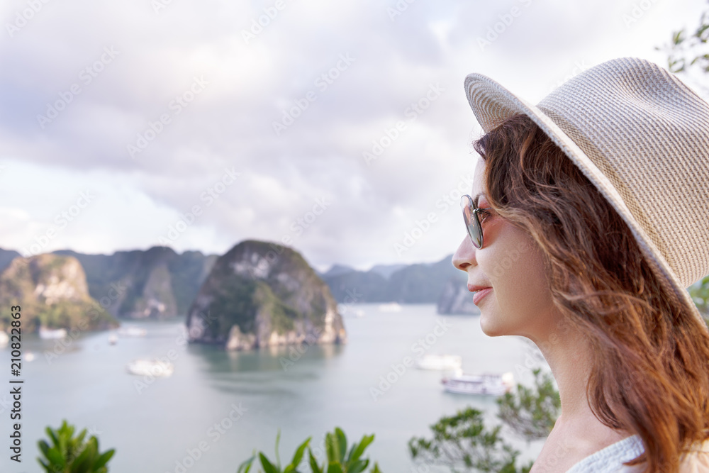 happy woman tourist in profile looking far away on sea and island background