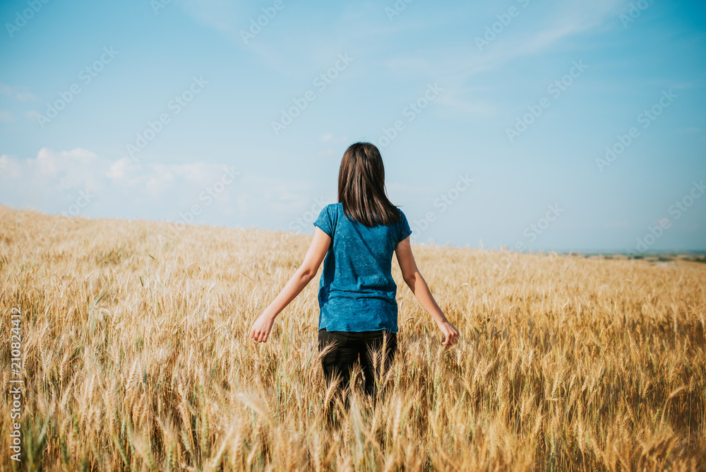 woman walking through wheat field, dolly shot. Girl's hand touching wheat ears. woman walking through wheat field, dolly shot. Girl's hand touching wheat ears.