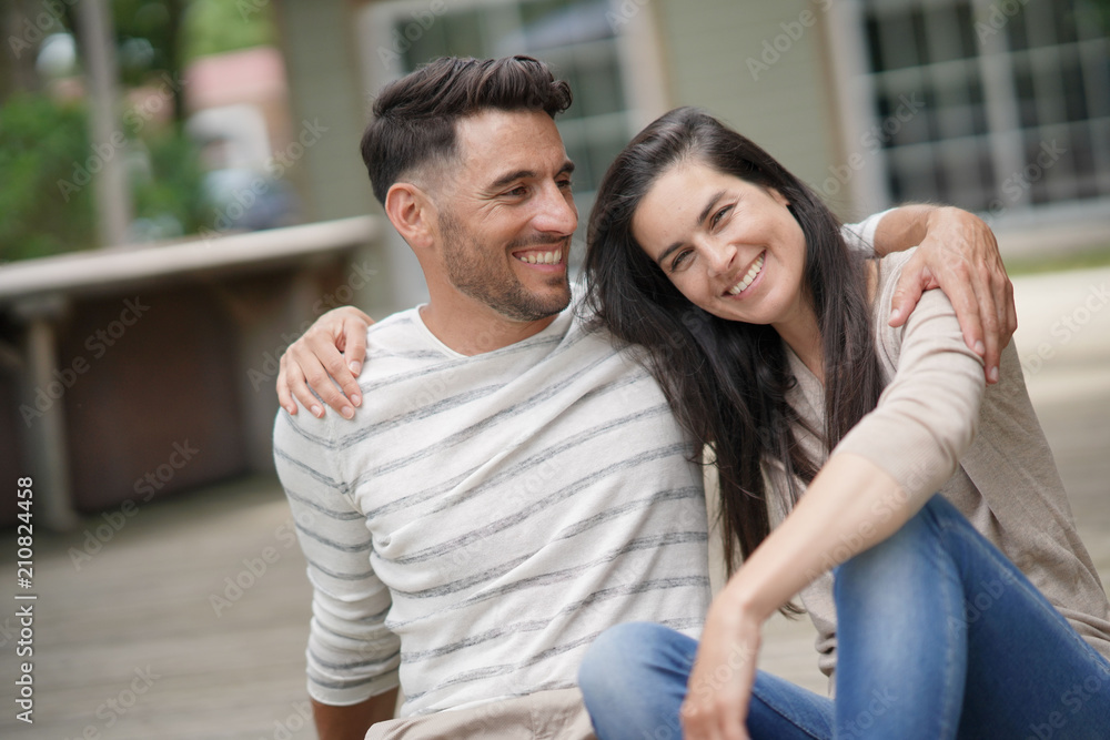 Couple relaxing in yard, embracing each other