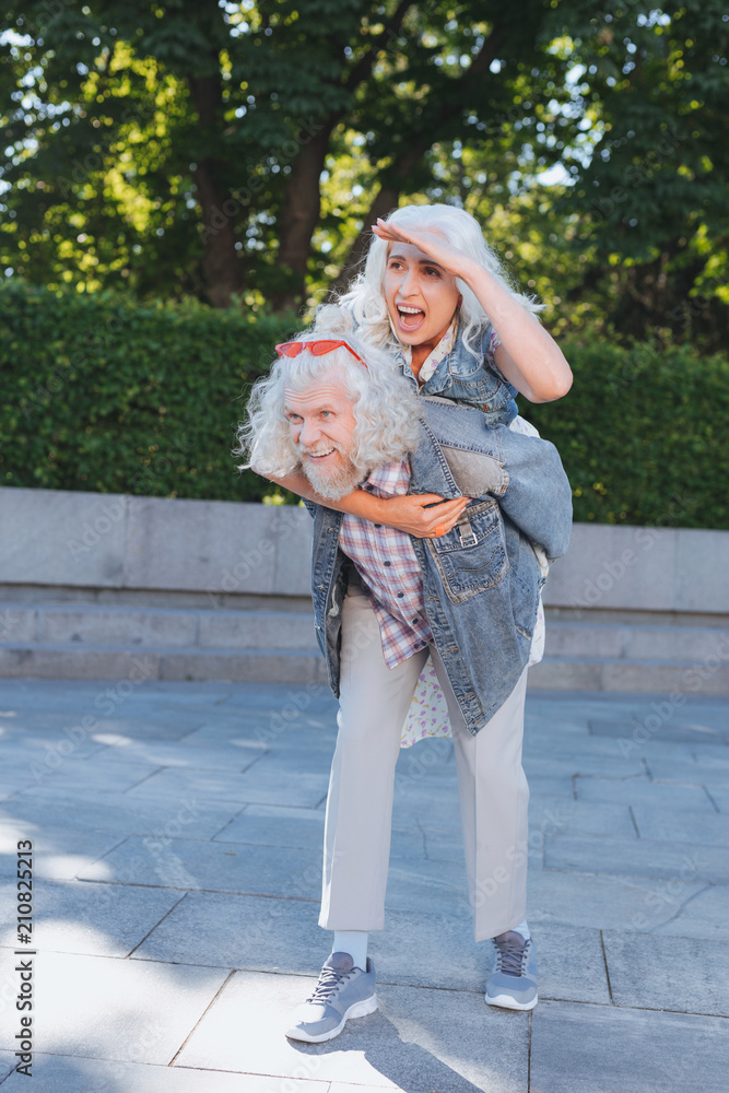 Pleasurable time. Cheerful aged woman laughing while having fun together with her husband
