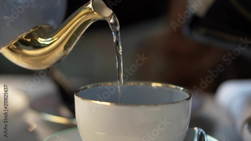 Slow motion pouring a cup of English tea in 120fps photo