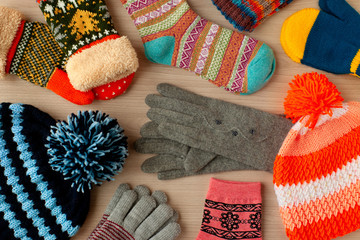 Autumn and winter clothes. Scattered warm clothes like hats, mittens, gloves and socks. Warm clothes for cold seasons. View from above.
