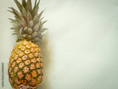 Pineapple on green background with copy space