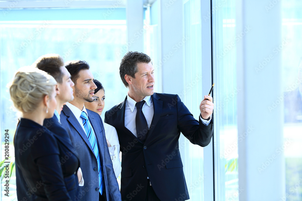 group of business people looking out the window,standing in the lobby of the office.