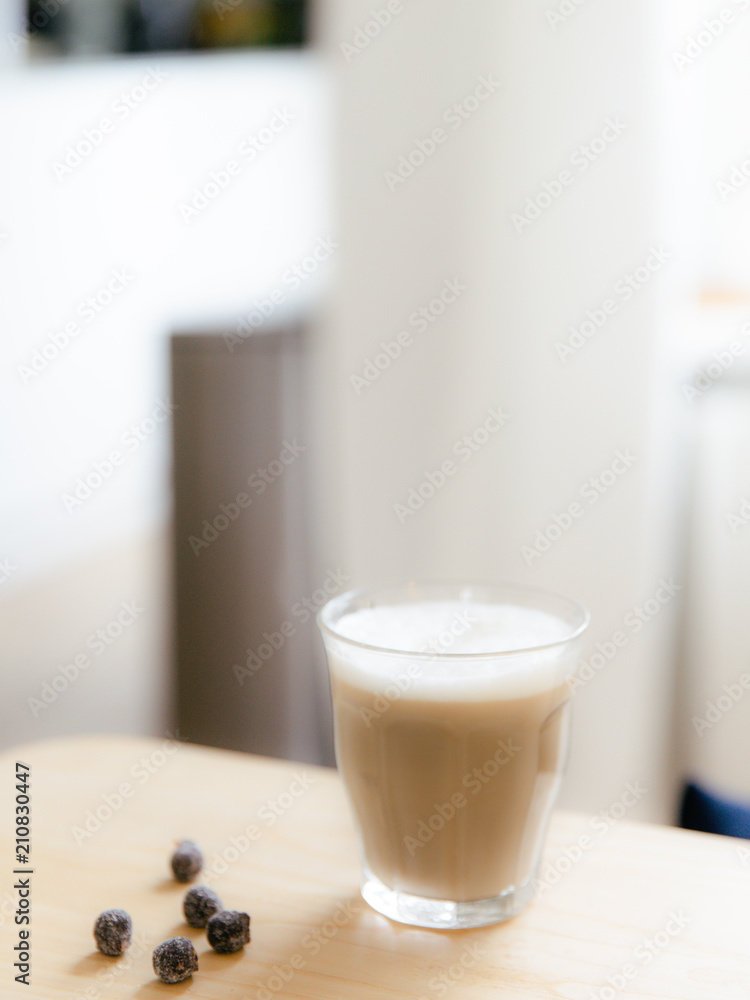 Cafe latte and a couple of healthy nibbles on a light wooden table during a coffee break. Cafe latte and a couple of healthy nibbles on a light wooden table during a coffee break.