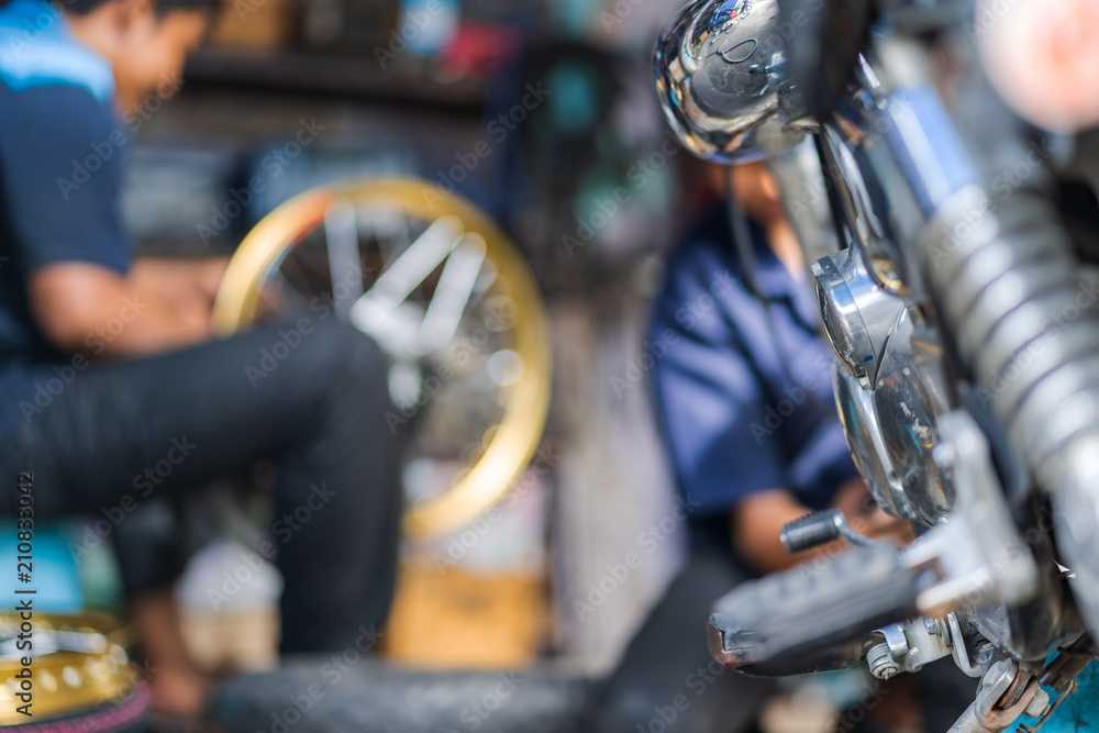 Automobile mechanic repairing motorcycle in bike repair shop Automobile mechanic repairing motorcycle in bike repair shop