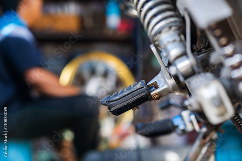 Automobile mechanic repairing motorcycle in bike repair shop