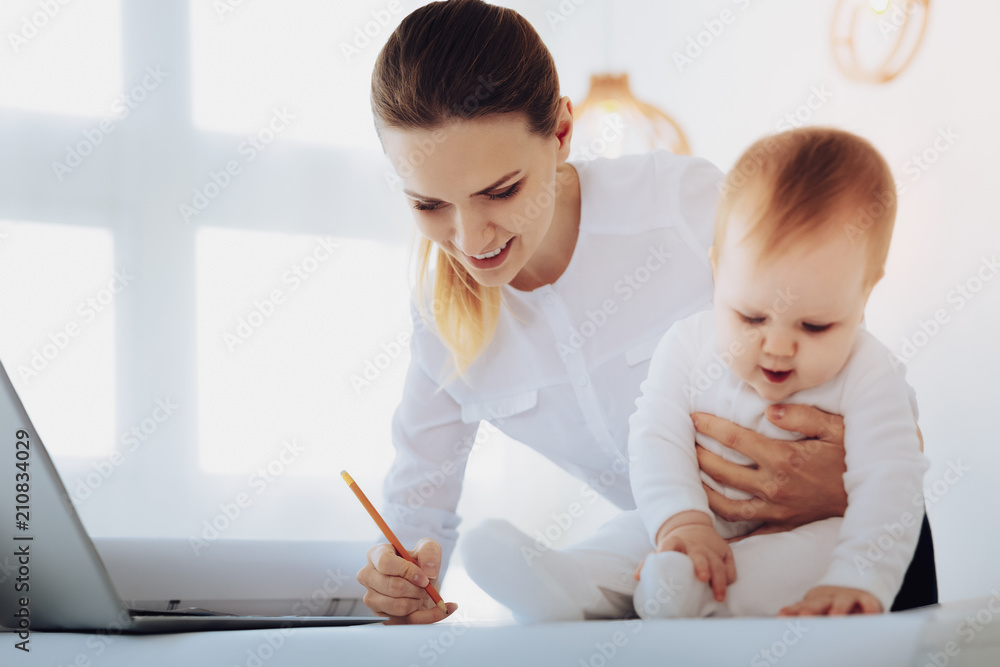 Being busy. Funny kid keeping mouth opened while touching little leg Being busy. Funny kid keeping mouth opened while touching little leg