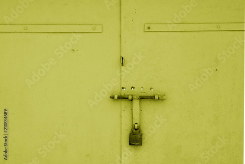 Old padlock on metal gate in yellow color. © pavelalexeev