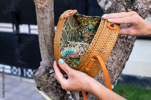 Fashionable stylish rattan bag outside. Tropical island of Bali, Indonesia. Rattan handbag.