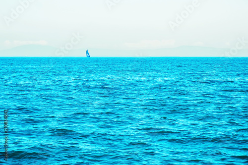 Lonely sailing boat in open sea. Beautiful romantic landscape, seascape. Luxury sports and recreation background. Horizontal image with copy space. 