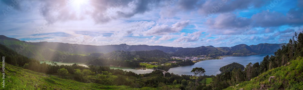 Beautiful sunset volcanic lake among mountains with green lush and trees in Ciete Cidades valley in Azores at San Miguel Island,.sunlight and clouds on the sky on background