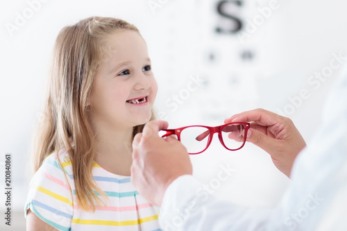 Child at eye sight test. Kid at optitian. Eyewear for kids. photo