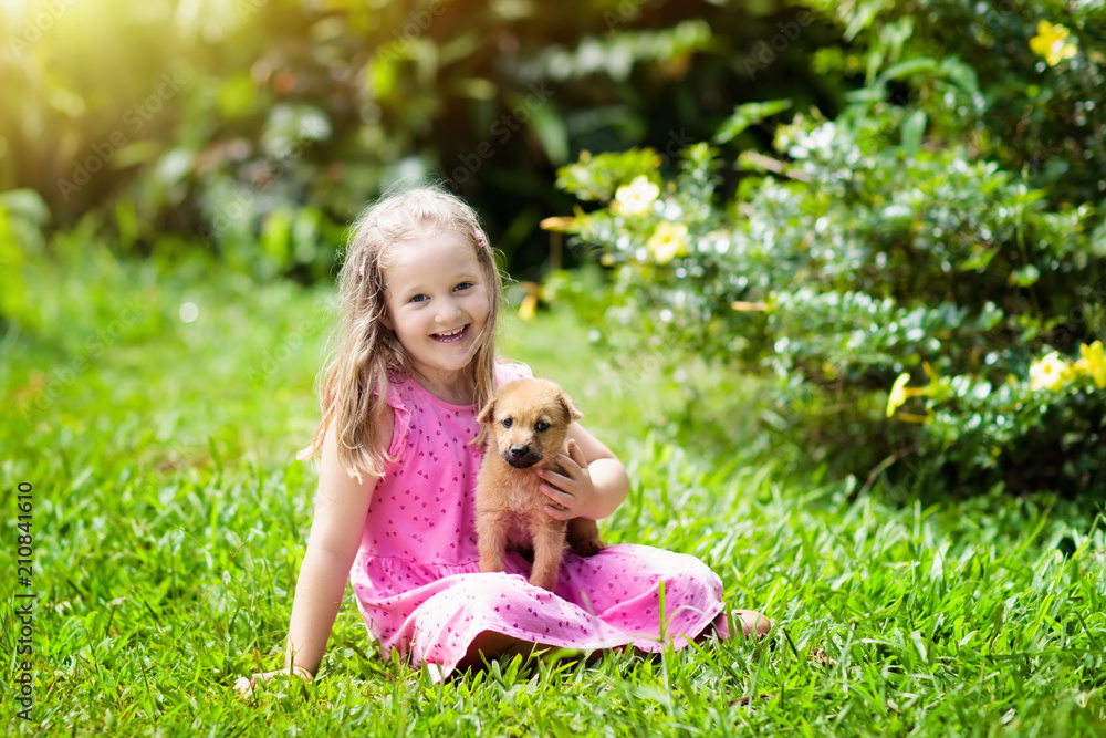 Kids play with puppy. Children and dog in garden. Kids play with puppy. Children and dog in garden.