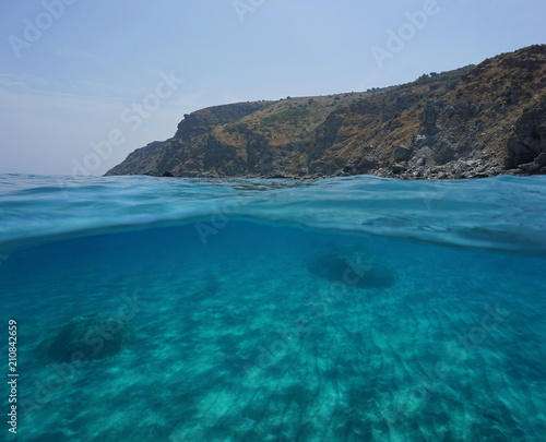 Coastal cliff and sand underwater, split view above and below water surface, Mediterranean sea, Marine reserve of Cerbere Banyuls, Pyrenees Orientales, France