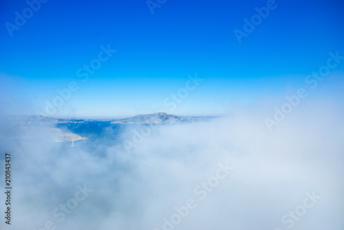 Marin headland and San Francisco bay on foggy day with clear blue sky