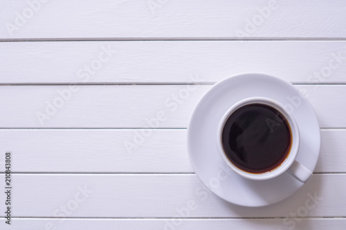 A cup of black coffee on rustic white wooden table with copy space.