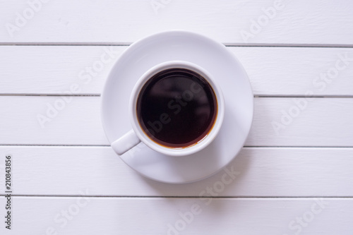A cup of black coffee on rustic white wooden table with copy space.