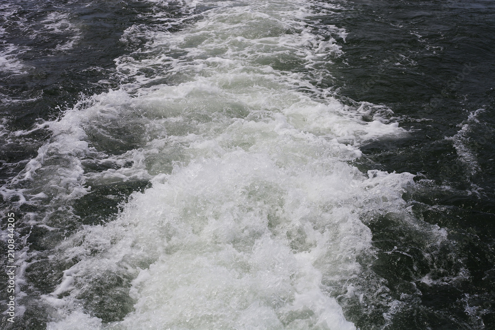 White sea foam on water from floating boat White sea foam on water from floating boat