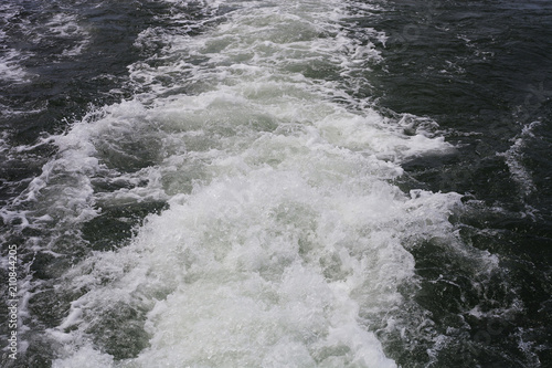 White sea foam on water from floating boat