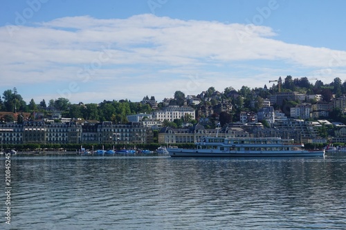 Blue lake in Lucerne in Switzerland with houses and boats and swans