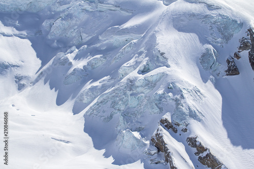 Snow-covered glacier in a Mountains of Saas-Fee in Switzerland photo