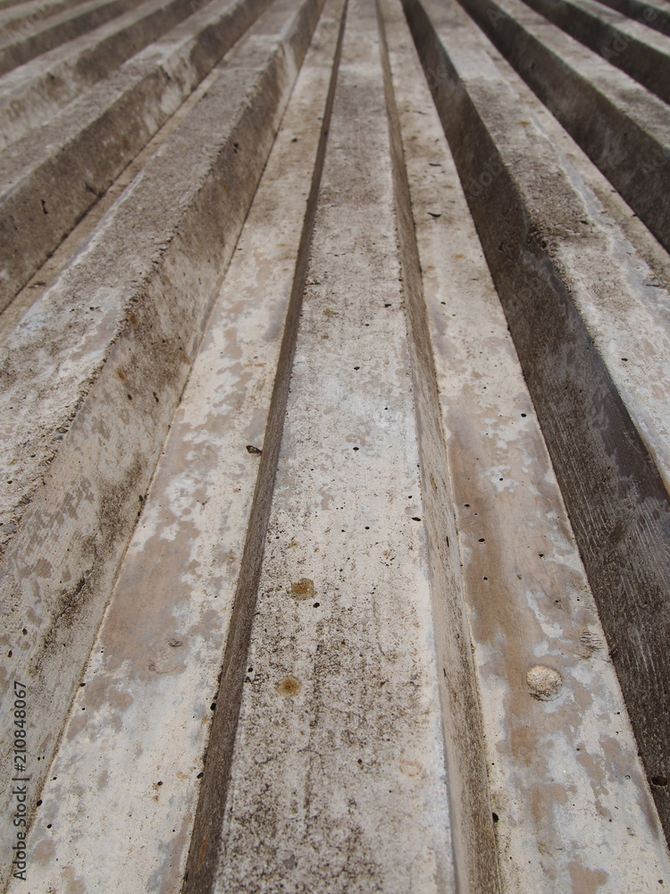 close up of cast concrete with vertical ribbed texture with a converging view in sunlight and shadow close up of cast concrete with vertical ribbed texture with a converging view in sunlight and shadow