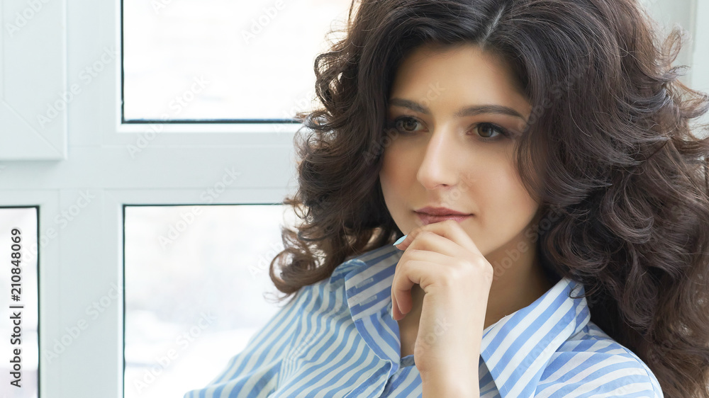 Girl with long curly hair. Stylish gorgeous girl in the luxury beauty salon. Girl with long curly hair. Beautiful sexy girl with hair sitting near the window in the dressing room. Girl with long curly hair. Stylish gorgeous girl in the luxury beauty salon. Girl with long curly hair. Beautiful sexy girl with hair sitting near the window in the dressing room.