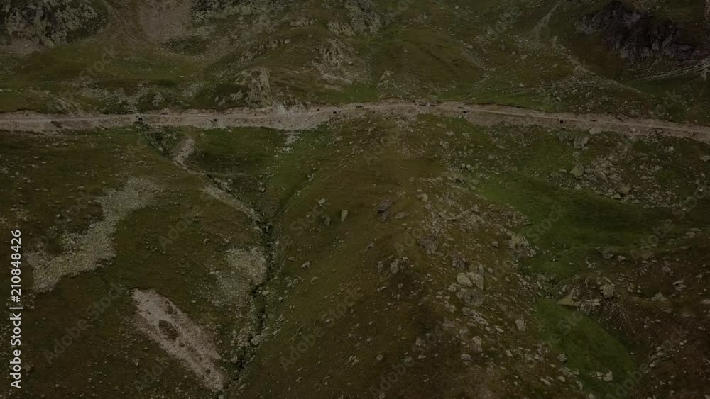 Aerial view. Drone rises over road with driving cars up in the mountains. Transalpina road in the Carpathians Romania Aerial view. Drone rises over road with driving cars up in the mountains. Transalpina road in the Carpathians Romania