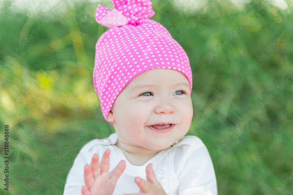 Smiling child in the grass. Hat in polka dots. Green grass. Smiling child. Smiling child in the grass. Hat in polka dots. Green grass. Smiling child.