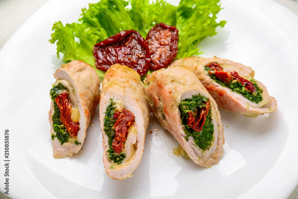 mini chicken rolls with dried tomatoes and spinach. festive dish. mini chicken rolls with dried tomatoes and spinach. festive dish.