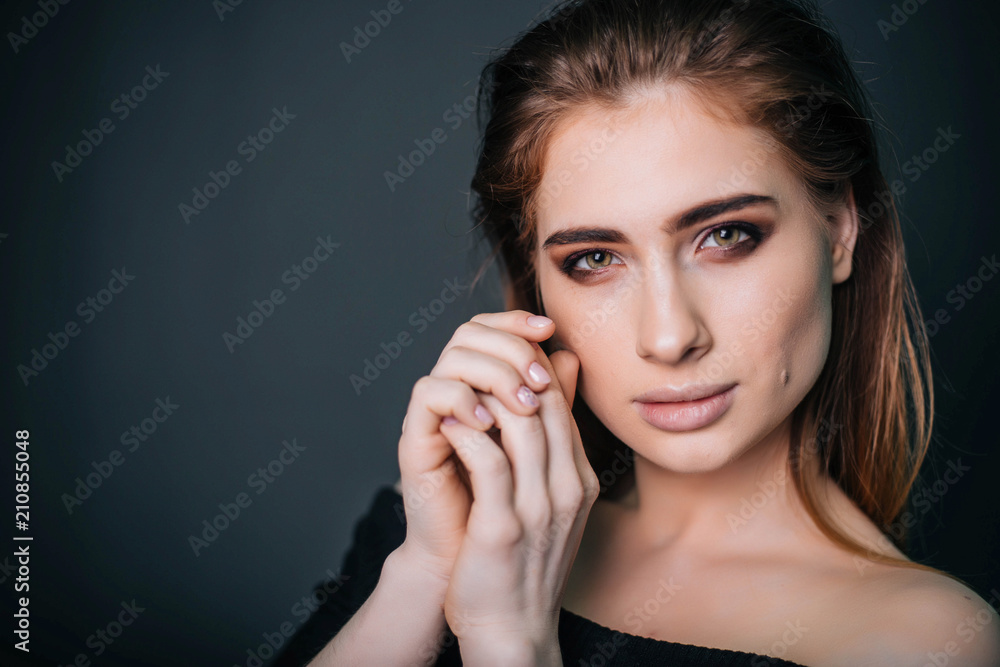 beauty portrait. Studio portrait of a beautiful girl on a gray background. Good make-up. Face close-up beauty portrait. Studio portrait of a beautiful girl on a gray background. Good make-up. Face close-up