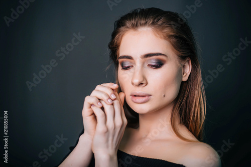 beauty portrait. Studio portrait of a beautiful girl on a gray background. Good make-up. Face close-up