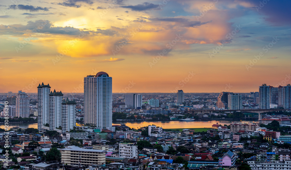 Fototapeta premium zmierzch panoramę miasta wzdłuż rzeki złote tło