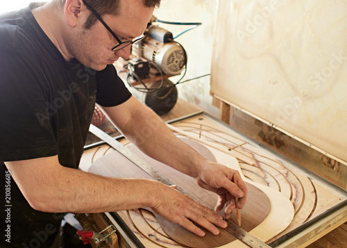 Marking and gluing of footer to the back deck of classical guitar. Production of classical guitar.
