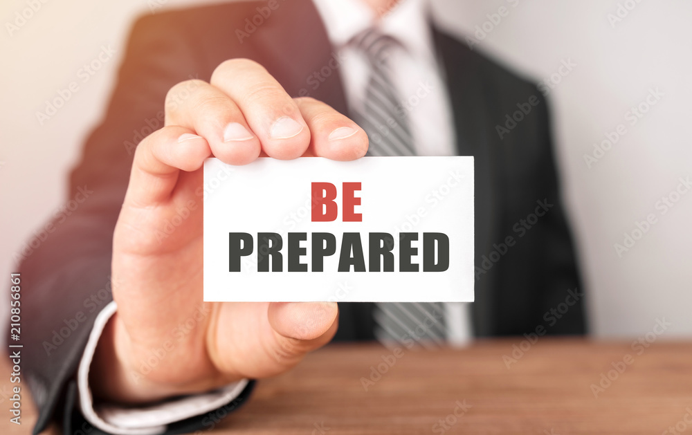 Businessman holding a card with text Be Prepared Businessman holding a card with text Be Prepared