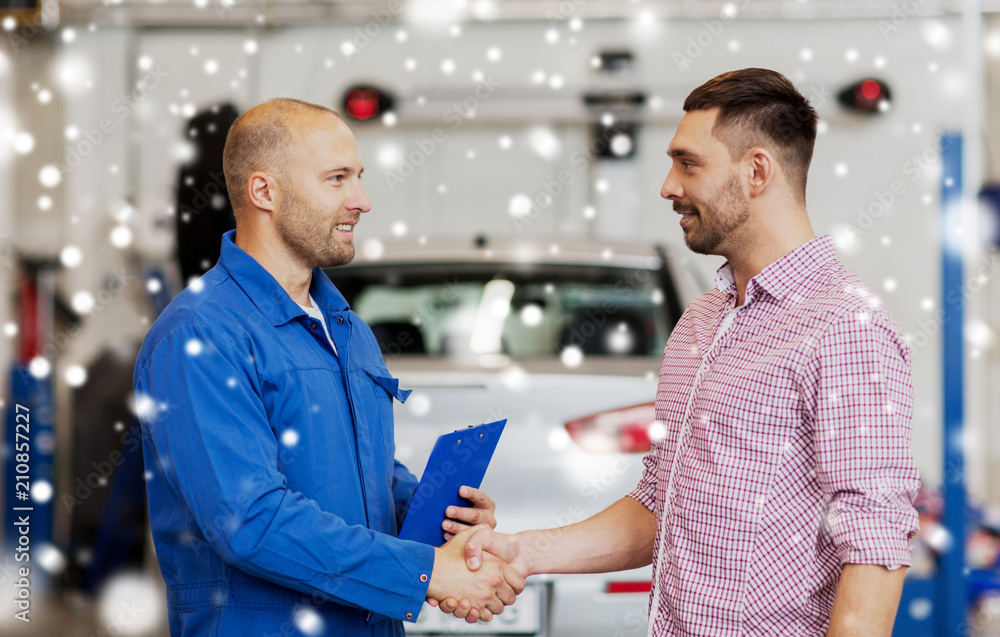 Obraz premium auto service, repair, maintenance, gesture and people concept - mechanic with clipboard and man or owner shaking hands at car shop